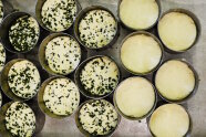 Ausgeformter Käse mit und ohne Kräuter vor der Reifung