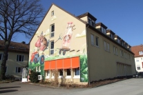 Unterrichts- und Wohngebäude der Fachschule mit Milch-Graffiti